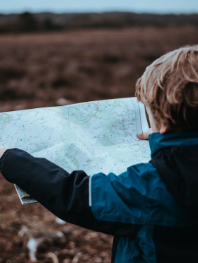 Niño leyendo un mapa de papel